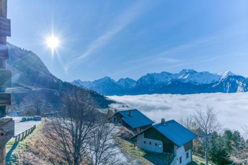 a house with a blue roof on top of a snowy mountain at Chalet le Regain in Villard-Reculas