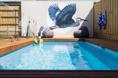 a swimming pool with a bird painted on the wall at Rosewood Retreat New luxury Home in Rosebud