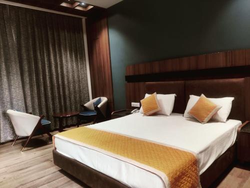 a bedroom with a bed and a table and chairs at Nirvana Grand Hotel & Resort in Gaya