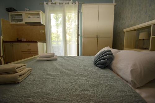 a bedroom with a large bed with towels on it at Apartments and Rooms Frane in Palit
