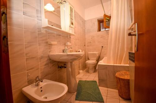 a small bathroom with a sink and a toilet at Apartments and Rooms Frane in Palit
