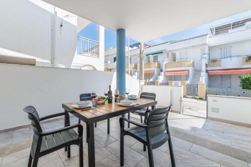 - Mesa de comedor y sillas en el balcón de un apartamento en Dimora da mare, en Marina di Pescoluse