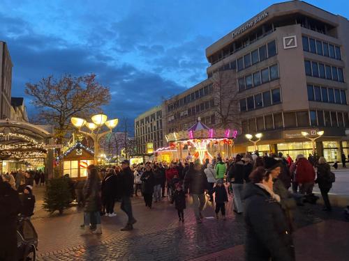 a crowd of people walking around a city with christmas lights at Hotel Am Sportpark in Duisburg