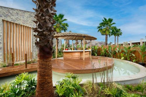 a resort with a pool with a table and a palm tree at Regnum The Crown in Belek
