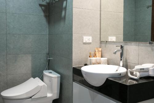 a bathroom with a white toilet and a sink at NINE HOUSING 49 Linh Lang in Hanoi