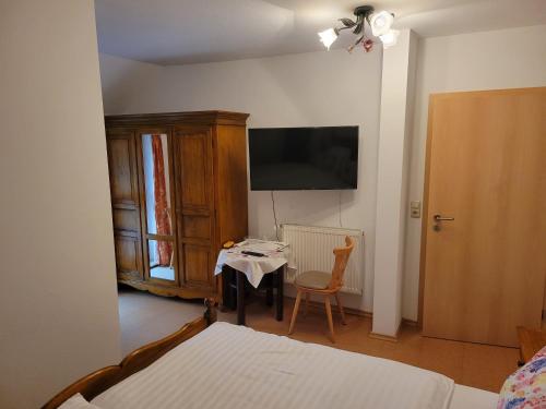 a bedroom with a bed and a table and a television at Weingut Herbert Kram in Nordheim