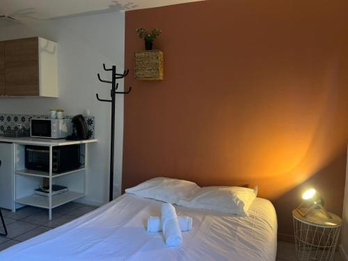 - une chambre dotée d'un lit avec une croix sur le mur dans l'établissement Le Vinci, à Calais