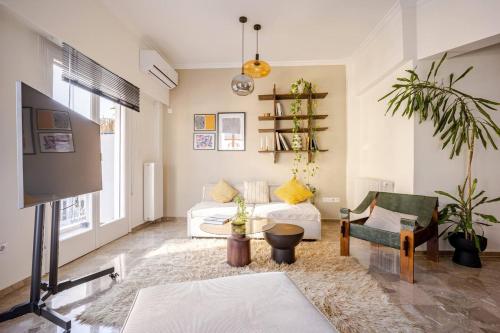 a living room with a couch and a tv at Marthas Loft Lycabettus Athens in Athens