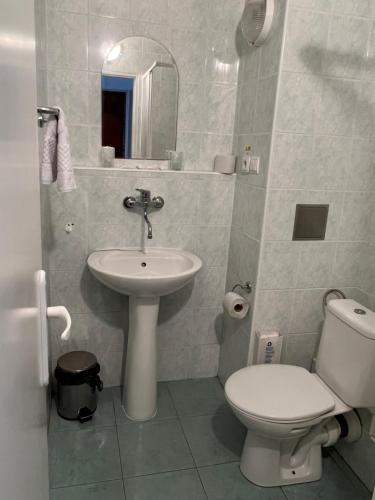 a bathroom with a white toilet and a sink at Hotel Pelikán in Lučenec