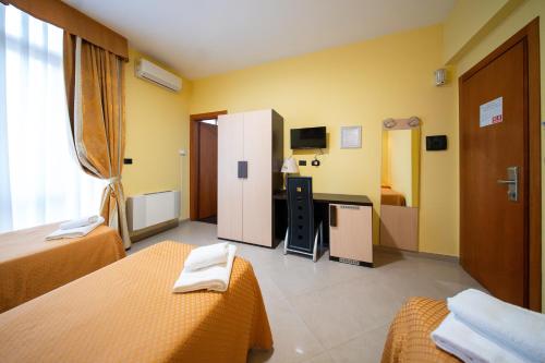 a hotel room with two beds and a desk at Hotel Residence Sestriere in Moncalieri