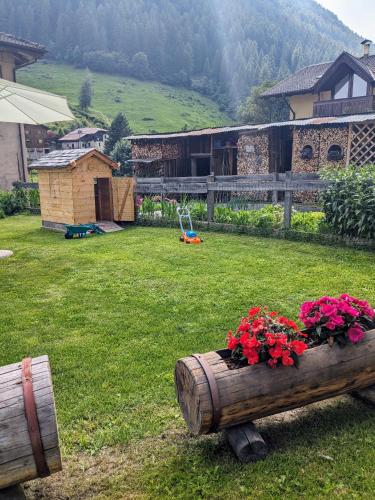 a yard with a wooden barrel with flowers in it at Casa vacanze Heidi e Peter Val di Rabbi in Rabbi