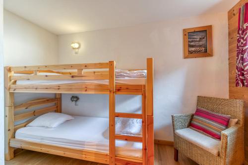 a bedroom with two bunk beds and a chair at Chalet le Regain in Villard-Reculas