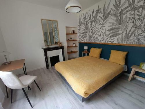 une chambre avec un lit, une table et une chaise dans l'établissement La chouette dans l'arbre - T2 sur cour au calme, à Dijon