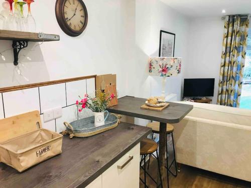 a kitchen with a table and a clock on the wall at Hot tub - Number 37 in Llansantffraid Glan Conwy