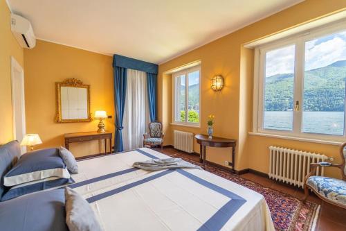une chambre avec un grand lit et une grande fenêtre dans l'établissement Lakefront 1800s Villa Private Dock, Art Luxury, à Carate Urio