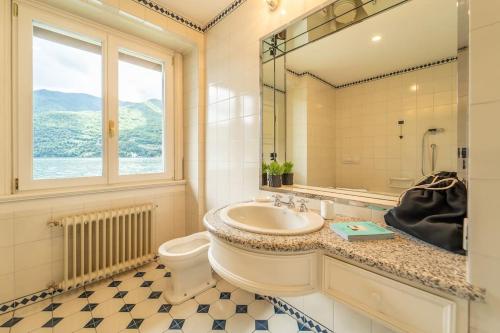 une salle de bain avec un lavabo et des toilettes et une fenêtre dans l'établissement Lakefront 1800s Villa Private Dock, Art Luxury, à Carate Urio