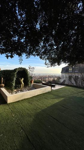 a garden with a statue in the middle of a yard at MiHotel Le Gourguillon in Lyon