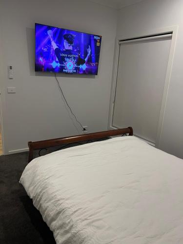 a bedroom with a bed and a flat screen tv on the wall at Welcome home in St Albans