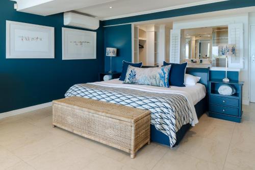a blue bedroom with a bed and a mirror at Last Word Long Beach in Kommetjie