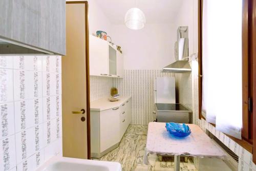 Una pequeña cocina con gabinetes blancos y un fregadero. en Casa Ester, en Arenzano