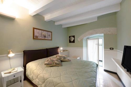 Un dormitorio con una cama y un televisor. en Casa Fiordaliso, en Arenzano