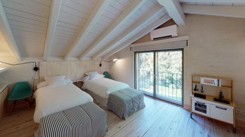 Un dormitorio con dos camas y una gran ventana. en Abejas 1 de El Vergel de Chilla, en Candeleda