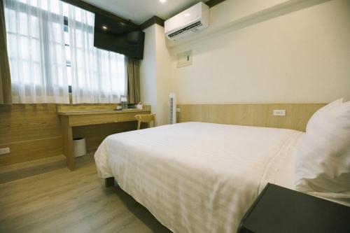 a bedroom with a bed and a desk in it at 許家古宅 4-6人包棟民宿 in Tainan