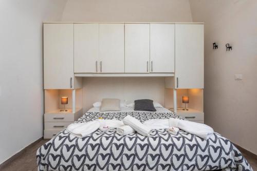 カターニアにあるBED.da Catania Apartmentのベッドルーム1室(大型ベッド1台、白いキャビネット付)