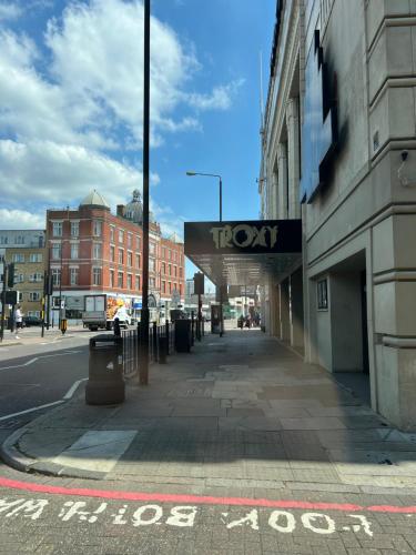 an empty city street with buildings and a sign that reads rolex at Spacious rooms for rent 10 min from Tower Bridge in London