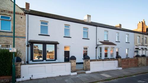 a white house with windows on a street at YSS The Church 1 Coatham in Redcar