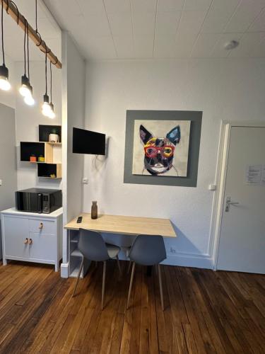 une chambre avec une table et une photo d'un chien dans l'établissement Émeraude 1, à Vichy