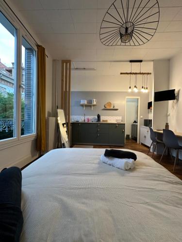 une chambre avec un grand lit blanc dans une pièce dans l'établissement Émeraude 1, à Vichy