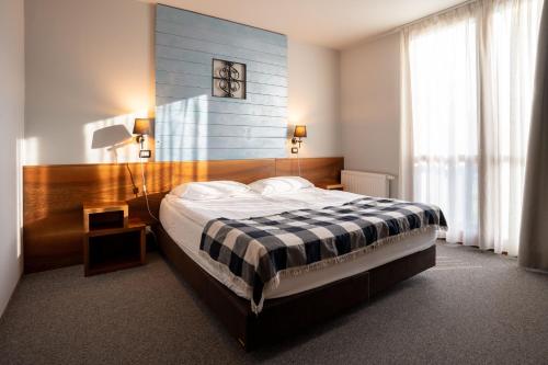 a bedroom with a bed with a black and white blanket at Hotel Boka in Bovec