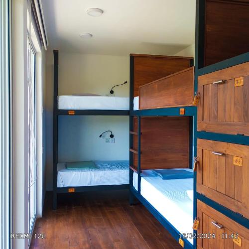 two bunk beds in a room with wooden floors at The Cubes Ella in Ella
