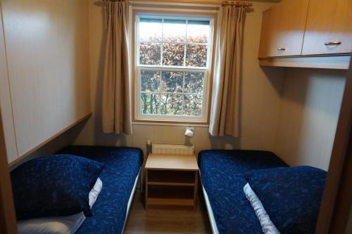 Кровать или кровати в номере Kustverhuur, Groede Paarlhof 51