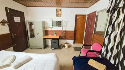 ein Schlafzimmer mit einem Bett, einem Schreibtisch und einem Tisch in der Unterkunft Honolulu Home in Kochi