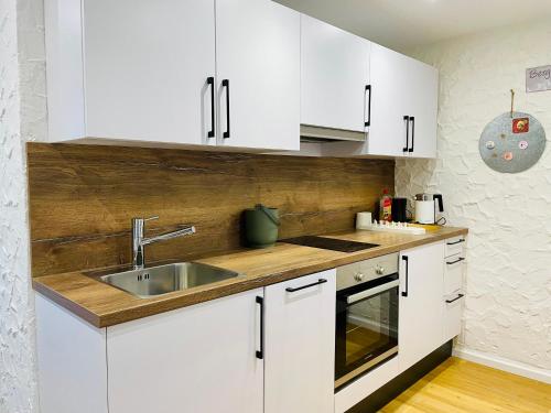 a kitchen with white cabinets and a sink at Jopachalets Pfronten in Pfronten