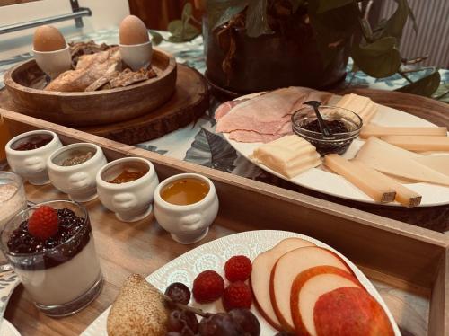 een tafel met kaas en andere voedingsmiddelen bij ÔTroisChênes - Gîte au calme avec spa privatif in Saint-Astier