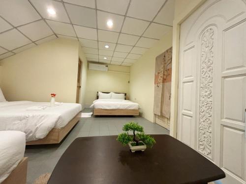 a bedroom with two beds and a table with a plant at Apamet Hotel Sukhumvit 55 in Khlong Toei