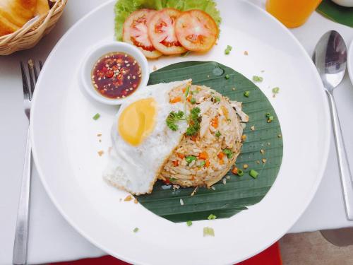 a plate of food with a fried egg on a banana leaf at Siem Reap Center Hotel in Siem Reap