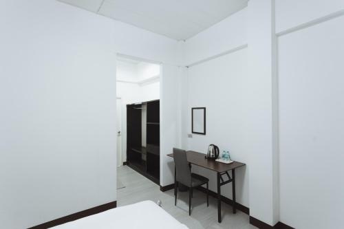 a bedroom with a desk and a bed in a room at GO INN Maya - Nimman Chiang Mai in Chiang Mai