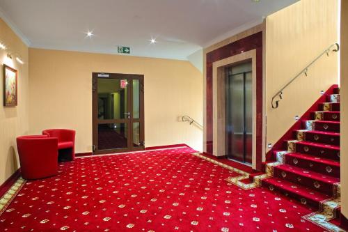 a room with a red carpet and stairs with a red rug at Podgrodzie in Kowal