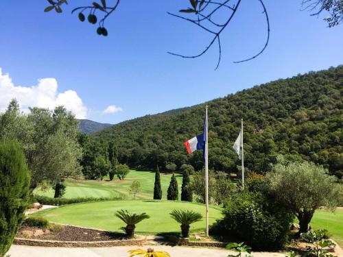 a golf course with a flag and a golf green at La Mandragora, belle Villa pour 6 personnes avec piscine à débordement et vue mer à La Londe-les-Maures in La Londe-les-Maures