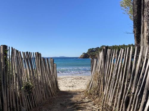 a wooden fence on a beach near the ocean at La Mandragora, belle Villa pour 6 personnes avec piscine à débordement et vue mer à La Londe-les-Maures in La Londe-les-Maures