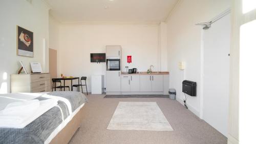 a white bedroom with a bed and a kitchen at YSS The Church 1 Coatham in Redcar