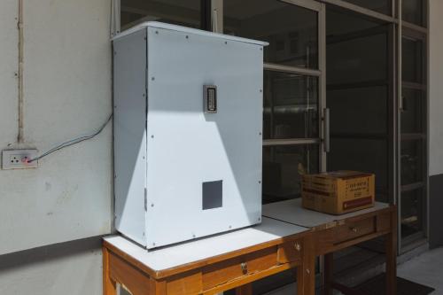 a white refrigerator sitting on top of a wooden table at GO INN Maya - Nimman Chiang Mai in Chiang Mai