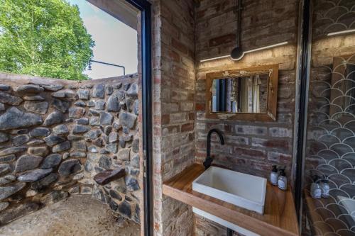 ein Badezimmer mit einer Steinmauer und einem Waschbecken in der Unterkunft Gartmore Guest Farm in Howick