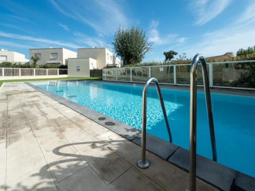 - une piscine avec des rails métalliques à côté d'un bâtiment dans l'établissement La Dune 16 - Villa 3P6, à Sérignan