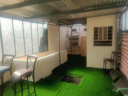 a room with two chairs and a green floor at Rudra The Stay in Jaipur