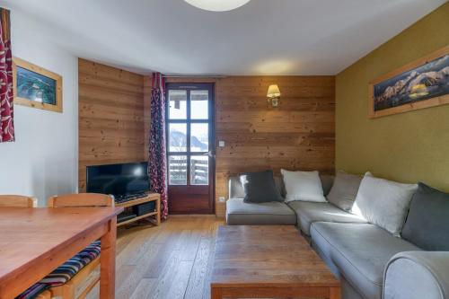 a living room with a couch and a tv at Chalet le Regain in Villard-Reculas